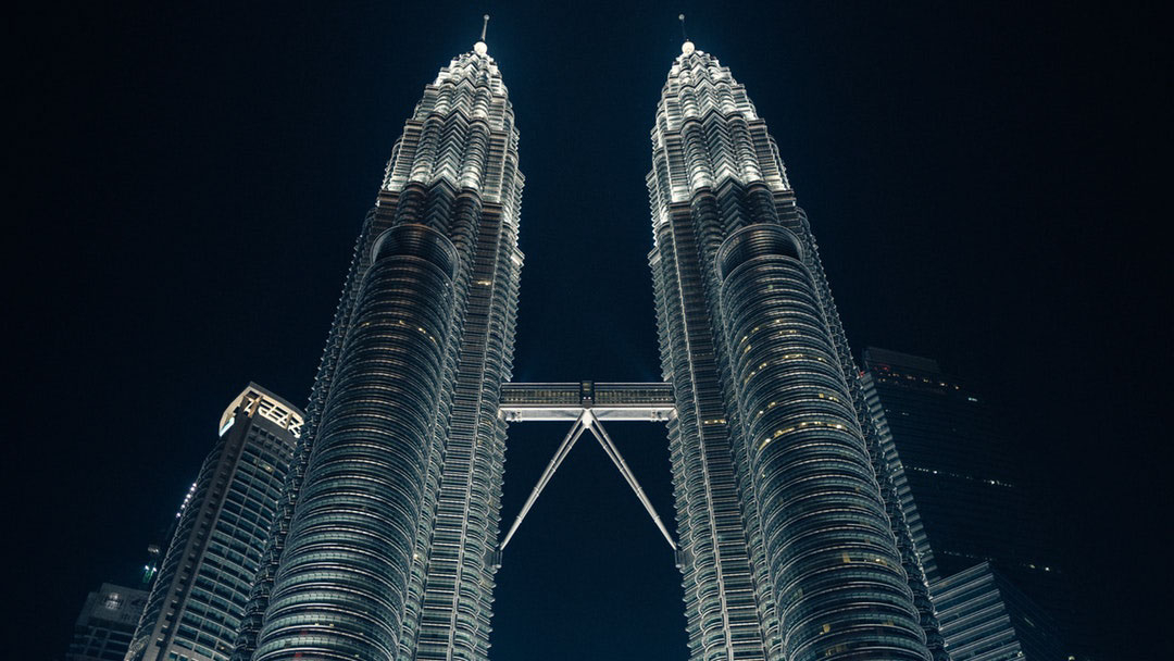 Night view of the Petronas Twin Towers in Kuala Lumpur, the concept of building a digital twin through MCAD and ECAD collaboration.