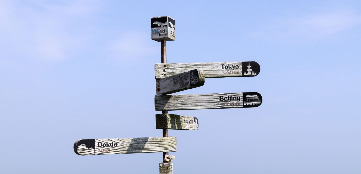 A signpost with multiple directions against a clear blue sky, representing the strategic decision-making process in leveraging megatrends for technological advancement and innovation in various industries.