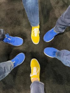 Six feet in a circular formation. 4 with bright blue shoes, and 2 with bright yellow.