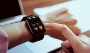 Wearable technology - Close-up of hand touching a smartwatch showing a health app on the screen.